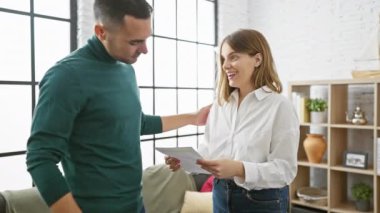 Neşeyi, ortaklığı ve ev hayatını yansıtan, aydınlık, modern bir oturma odasına bağlanan ve kucaklayan mutlu bir çift..