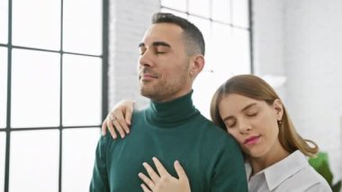 Sevgi dolu bir çift, aydınlık, modern bir oturma odasında kucaklaşır. Kapalı alanlarda sevgi ve rahatlığı ifade ederler..