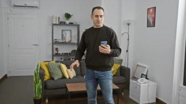 İspanyol adam akıllı telefon dansı yapıyor. Ev içi danslar yapıyor.