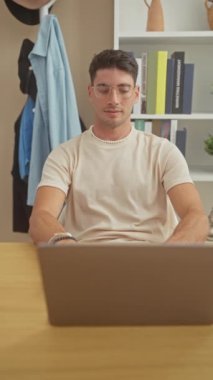 Ofiste laptopla gülümseyen yakışıklı İspanyol.