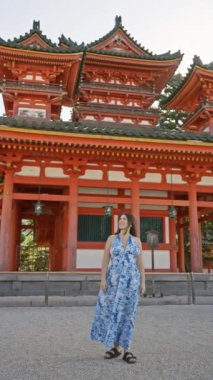 Güzel İspanyol kadın ayakta duruyor, eğleniyor ve gülümsüyor geleneksel jingu jingu türbesine bakarken, kyoto, japan