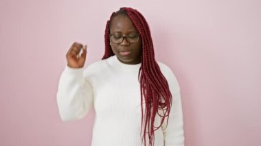 Gözlük takan düşünceli Afrikalı kadın ve pembe arka planda izole edilmiş beyaz süveter.