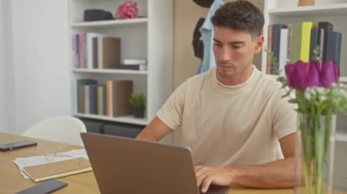 Evde dizüstü bilgisayar ve defterle meditasyon yapan yakışıklı İspanyol bir adam..