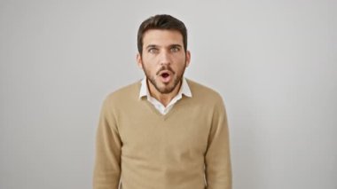 Süveterli, şoke olmuş, ağzı açık, inançsız genç bir İspanyol. Korkmuş, şaşırmış bir yüz, beyaz arka planda yalnız duruyor..