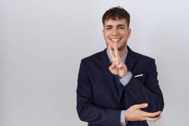 Genç İspanyol iş adamı takım elbiseli ve kravatlı, gülen yüzüyle kameraya bakıp zafer işareti yapıyor. İki numara.. 