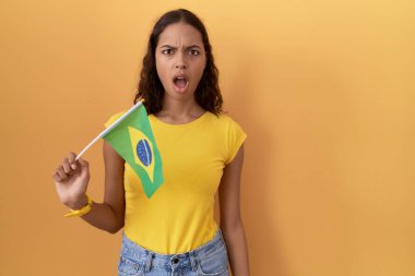 Şok olmuş yüzüne Brezilya bayrağı tutan genç İspanyol kadın şüpheci ve alaycı görünüyor, ağzı açık kalınca şaşırıyor. 