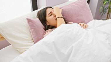 Genç İspanyol kadın rahat yatak odasında uyanıyor, kendini yenilenmiş hissediyor.