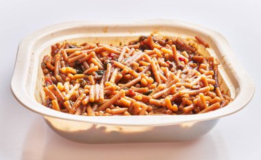 Beyaz arka planda beyaz bir fırında pişirilmiş fideua geleneksel İspanyol makarna tabağını sergiliyor..