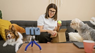 Genç bir İspanyol kadın evde bir video kaydederken köpekleriyle birlikte bir kutuyu açıyor..