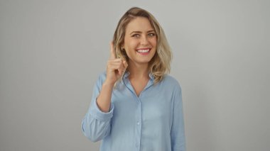 Beyaz bir arka planda, neşeli bir ifadeyle, sarı saçlı ve mavi gömlekli beyaz bir kadın..