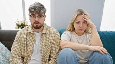 Kapalı bir koltukta oturan stresli bir çift, evde endişeli bir adam ve kadınla birlikte..