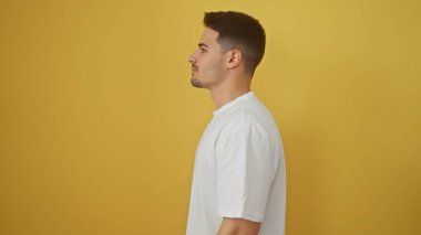 Sarı duvara karşı sakallı genç bir İspanyol 'un profili temiz bir portre çiziyor..