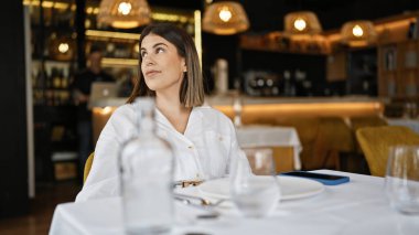 Genç, güzel, İspanyol bir kadın restoranın masasına bakıyor.