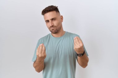 Hispanic man with beard standing over white background doing money gesture with hands, asking for salary payment, millionaire business 