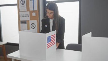 Genç bir İspanyol kadın, bir Amerikan seçim koleji odasında bayrak sallayarak oy kullanıyor.