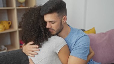 Sevecen bir çift, sıcak oturma odalarında kucaklaşıp, sevgi ve rahatlık iletiyorlar..