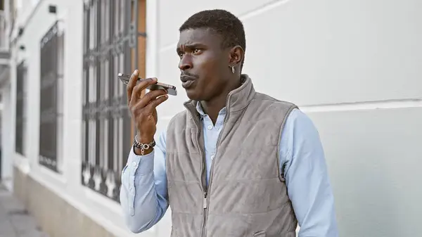 stock image Handsome black man using voice recorder on smartphone on urban city street