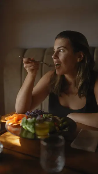 Nuori Latinonainen Nauttii Terveellisen Aterian Modernissa Ravintolaympäristössä Kuvaten Relatable Ruokailukokemusta — kuvapankkivalokuva