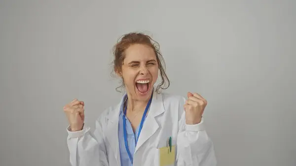 Aufgeregte Ärztin Feiert Erfolg Vor Weißem Hintergrund Mit Geballten Fäusten — Stockfoto