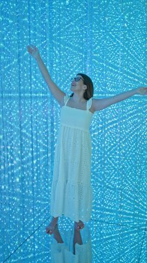 Gözlüklü güzel İspanyol kadın modern müzede fütüristik ışık sergisi açtı. Yaratıcılık ve mutluluğu ateşleyen bir sanat sergisi.