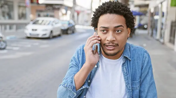 stock image Handsome man with curly hair talking on phone in urban street setting