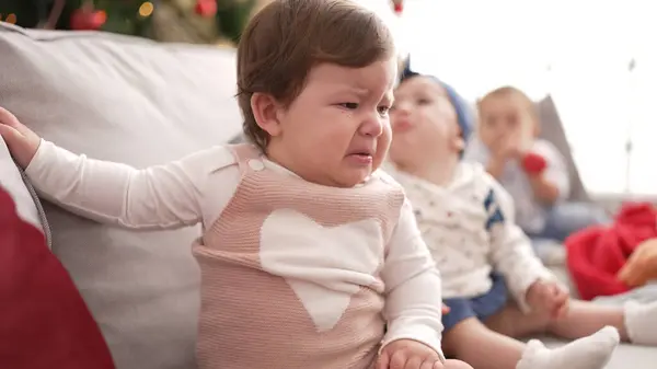 stock image Two adorable toddlers sitting on sofa crying at home