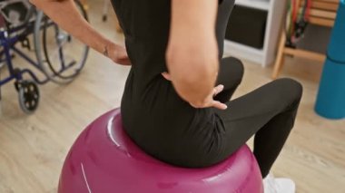Olgun bir kadın rehabilitasyon kliniğinde spor yapıyor. Terapi, sağlık ve aktif yaşlanma belirtileri gösteriyor..