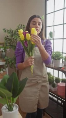 Genç İspanyol bir çiçekçi, ayışığı altındaki bir çiçekçide taze sarı laleleri inceliyor..