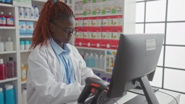 Eczanede bilgisayar kullanan Afrikalı kadın eczacı.