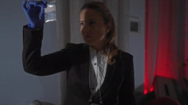 Odaklanmış bir kadın dedektif, delilleri kapalı bir yerde inceler, profesyonellik ve detaylara dikkat gösterir..