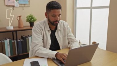 Masada uyuyakalmadan önce evde dizüstü bilgisayarla çalışan sakallı, Afro-Amerikalı bir adam..