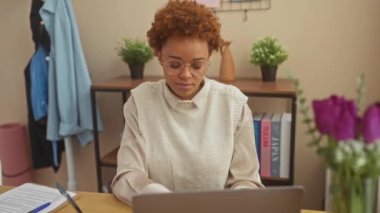 Komik bir ev anı, güzel bir Afrikalı Amerikalı kadın masada oturuyor, yanaklarını şişiriyor ve çılgın komik bir yüz ifadesi takınıyor, ağzı hava doluyor.