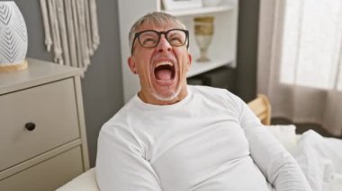 Hüsrana uğramış orta yaşlı, gri saçlı, pijamalı bir adam öfkeyle bağırıyor yatak odasında öfkesini kusuyor. Saf öfke ve saldırganlığın vücut bulmuş hali..