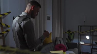 Dedektif, modern bir apartman dairesinde suç mahallini inceliyor..