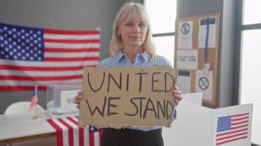 Oy verme merkezinde Amerikan bayraklarıyla vatansever işareti tutan sarışın kadın.