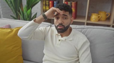 Stresli, başı elinde, endişeli ve endişeli, evdeki kişisel krizle ilgilenen İspanyol bir adam.