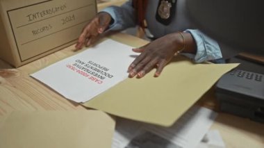 Afrika kökenli Amerikalı kadın dedektif polis karakolundaki sorgulama kayıtlarını inceliyor.