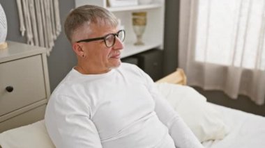 Mutlu orta yaşlı adam, gri saçlı ve ışıl ışıl, pijamadaki bir numaralı işaret işaretini zekice düşünerek yatak odası başarısını gösterdi..