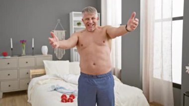 Neşeli orta yaş, gri saçlı adam, aşk sarılması için kollarını aç; kameraya gülümse; mutluluğun neşeli üstsüz sarılması