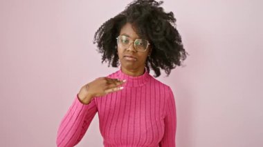 Gözlük takan kızgın Afro-Amerikalı kadın bıçak hareketiyle boğazını kesmekle tehdit ediyor. Klinik alanda duran saldırganlık ve şiddet portresi.