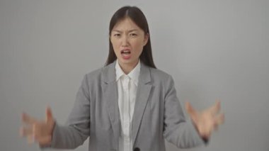 Aşırı öfke, çılgın Çinli kadın ifadesi, ceket giymiş, kollarını kaldırmış, çılgınca bağırıyor ve beyaz arka planda izole bir şekilde bağırıyor.