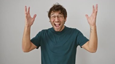 Kendinden geçmiş genç İspanyol adam, gözlük takıyor, kolları başarıyla havada. Çılgınca heyecanla kutlanan, uçuk kaçık bir kazanan. Beyaz bir arka planda izole edilmiş çılgın bir zafer.!