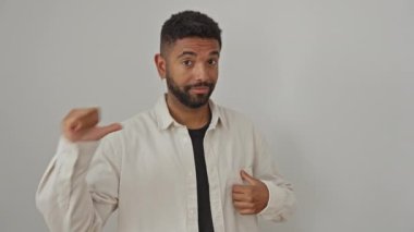 Genç, mutlu ve kendinden emin bir Afro-Amerikan erkeği, izole edilmiş beyaz arka planda dikilirken gururla kendini işaret ediyor, gömlek giyiyor ve kendinden emin görünüyor.