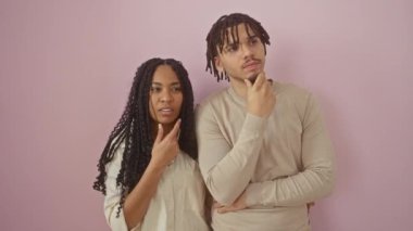 Şaşkın ve neşeli! Güzel bir çift, pembe izole bir arka plan üzerine fikirlerle dolup taşan aşk, güven ve özgüvenin bir ifadesi. 