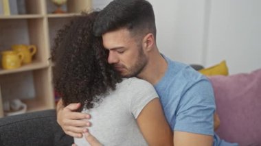 Modern bir oturma odasında bir erkekle bir kadın arasında sevgi dolu bir kucaklaşma..