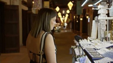 Genç bir kadın mücevher almak için Dubai 'de, Souk Madinat Jumeirah' ın geleneksel çevre ışıklandırmasından alışveriş yapıyor..
