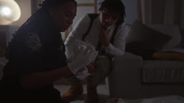 Bir kadın polis ve bir erkek, New York 'taki bir evdeki suç mahallini araştırıyor. İçerideki kanıtları değerlendiriyorlar..