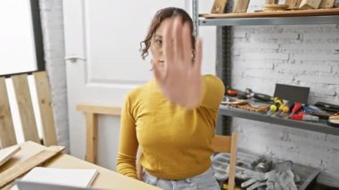 Kendine güvenen Afro-Amerikan kadın marangoz, marangozluk atölyesinde dizüstü bilgisayar kullanıyor.