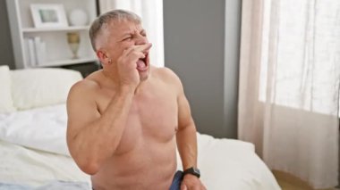 Yatakta beyaz saçlı, kolları açık, kafası karışık bir adam. Yaşlı, şaşkın, kayıtsız bir özürle belirsizlikle karşı karşıya. Evde, odada, bilinmeyenden omuz silker..