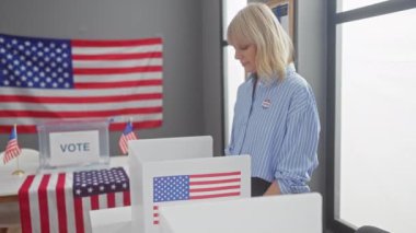 Sarışın bir kadın, bir Amerikan seçim sandık merkezinde bayrak ve 